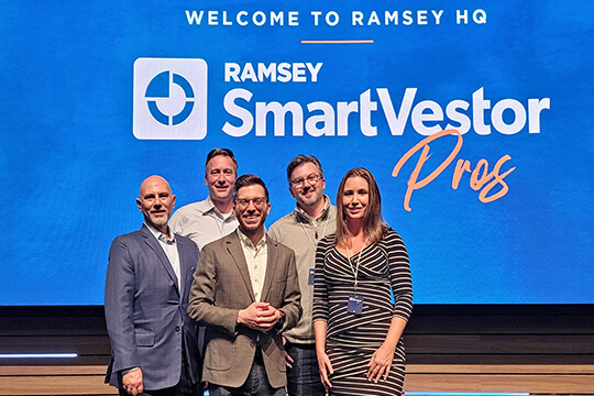 Group photo of five Vision Wealth Advisors team members in front of a blue screen with the Ramsey SmartVestor Pro logo at the Ramsey HQ